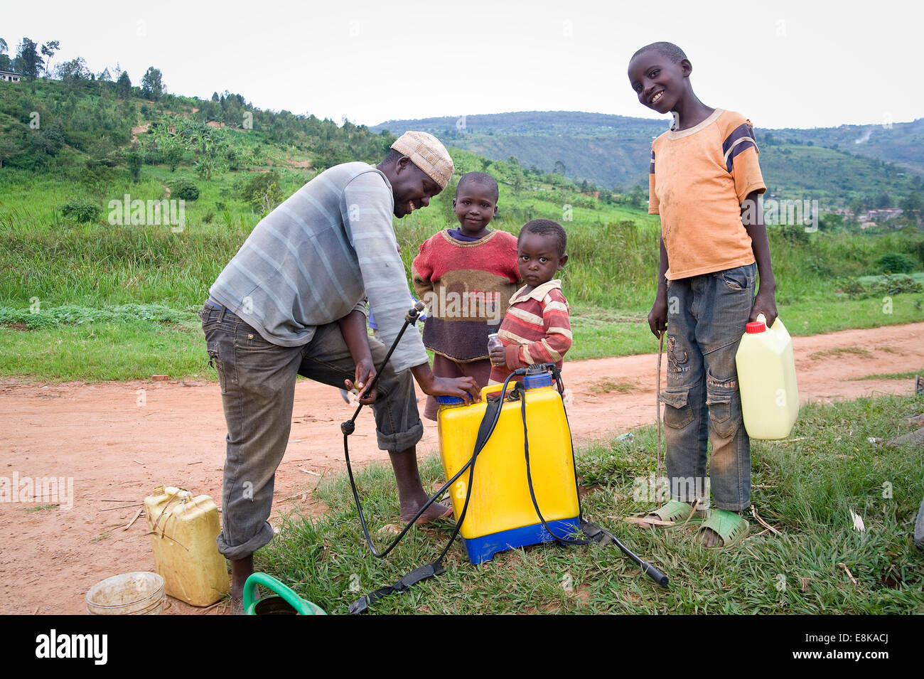 Le RWANDA, NJABORONGO VALLEY : Un homme de pulvérisations de pesticides pour les cultures sur un terrain en Afrique. Banque D'Images