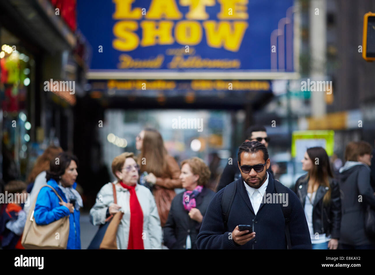 New York city NYC piétons attendre sur le trottoir, il attend de croix dans Times Square utilise son temps libre pour utiliser son téléphone mobile Banque D'Images