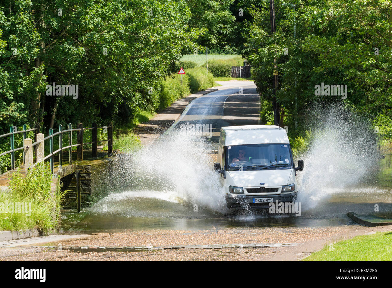 La conduite du véhicule par un gué sur la route et les projections d'eau. Rufford, Lancashire, England, UK Banque D'Images