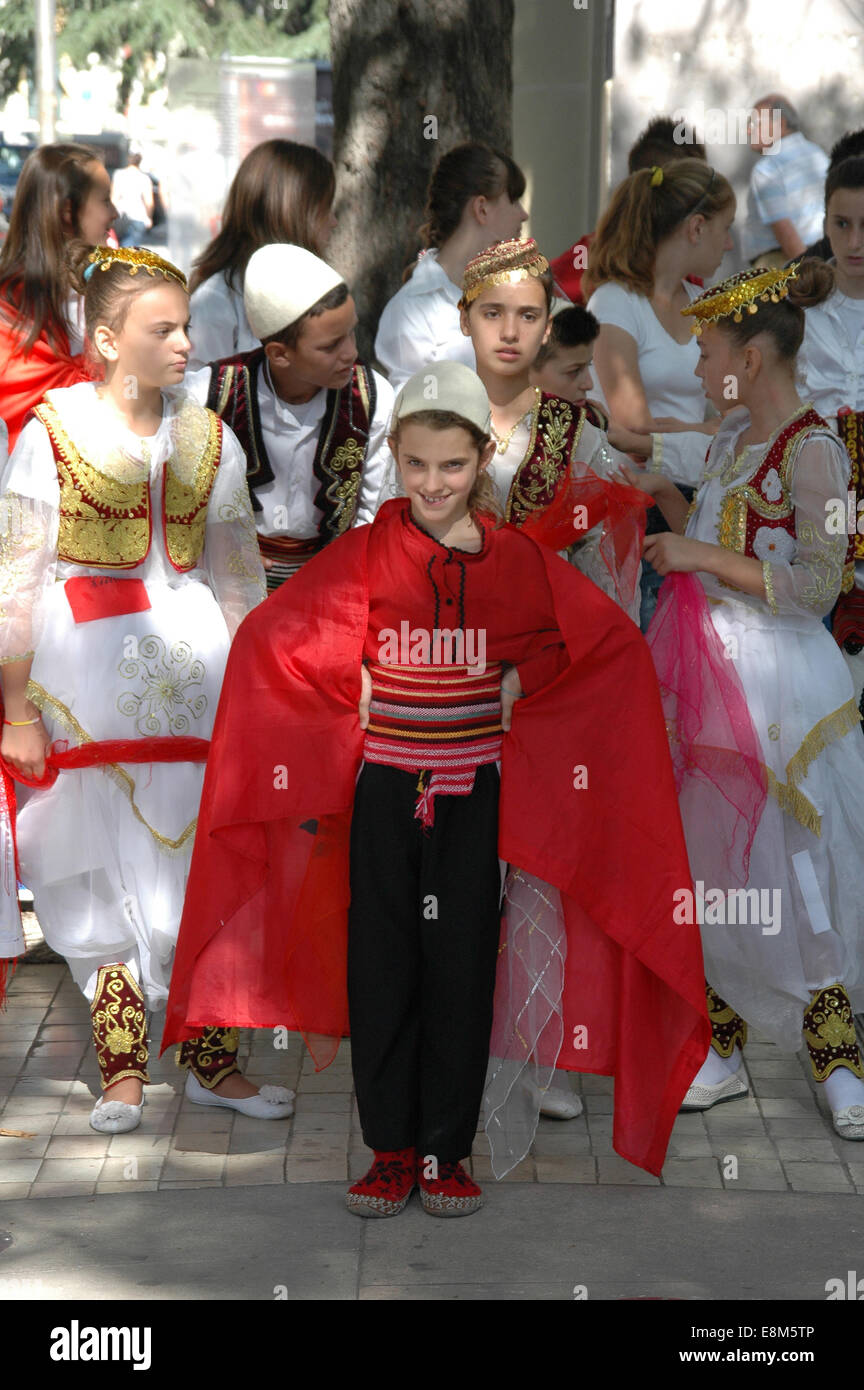 Fille albanaise traditionnelle de la scène de danse en costume historique et d'un drapeau Banque D'Images