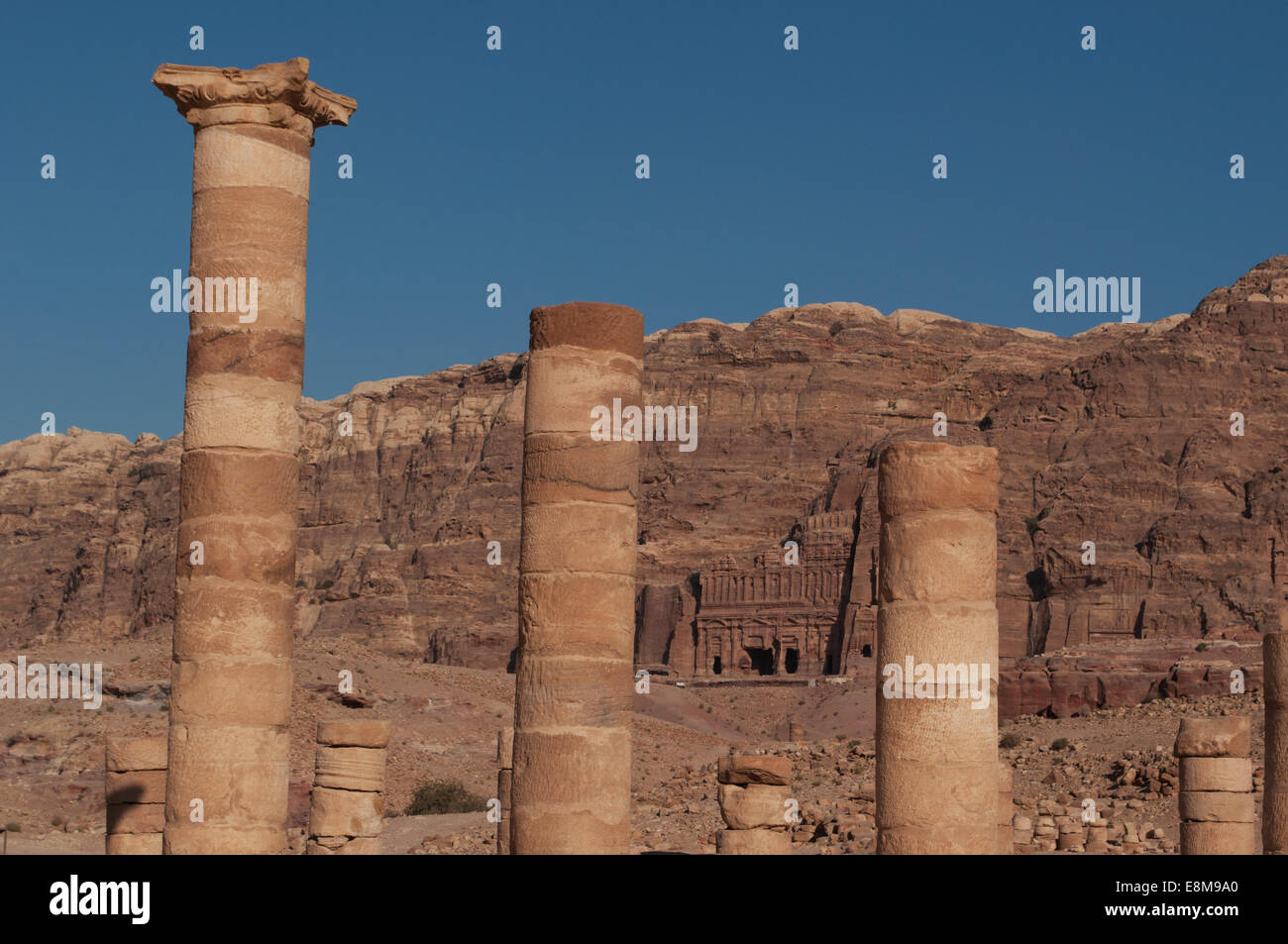 Petra : Kings mur avec les tombeaux royaux sculptés des structures funéraires, int la paroi rocheuse de la montagne vue à travers les colonnes du Grand Temple Banque D'Images