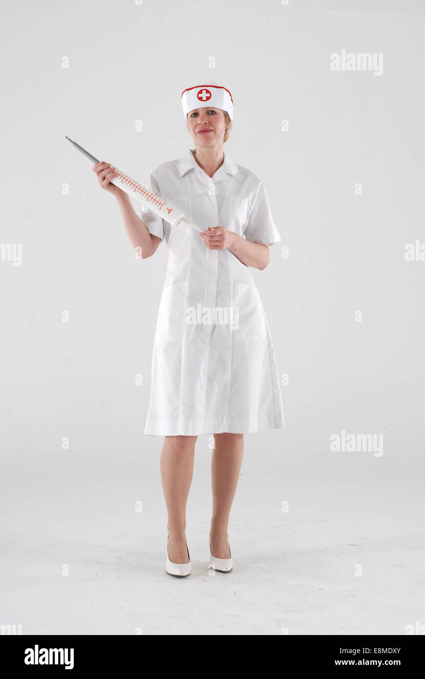 Woman in fancy dress costume de comédie dans un costume avec les infirmières seringue géante Banque D'Images