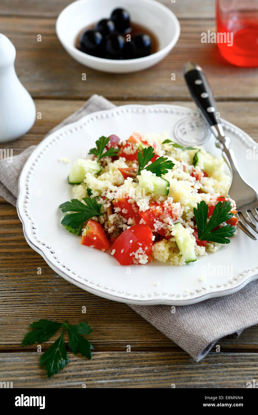 Avec salade de couscous cuit et les légumes sur une assiette blanche, des aliments nutritifs Banque D'Images