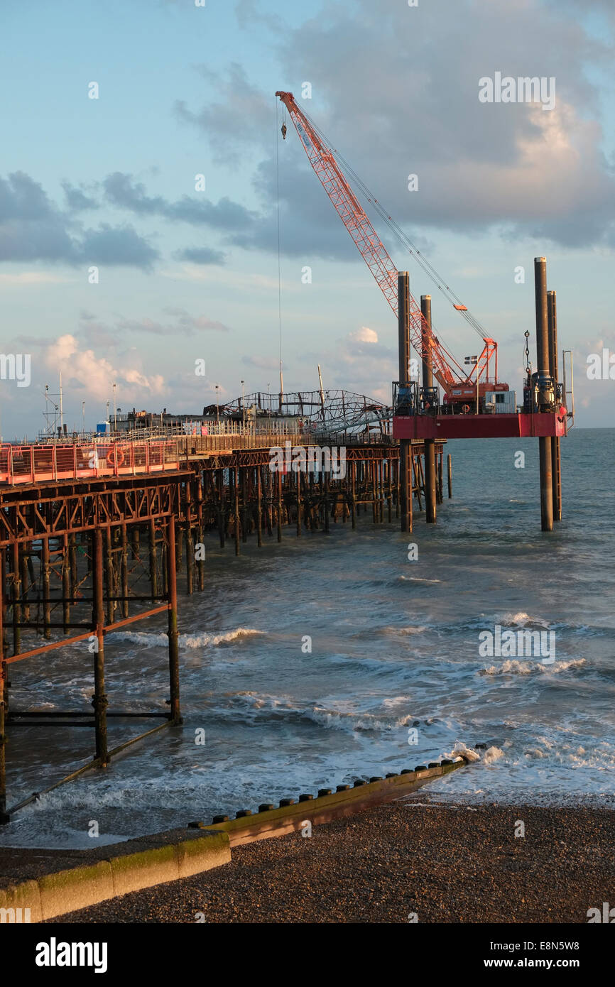 Hastings East Sussex Royaume-Uni, 11 octobre 2014. La grue et la barge coûtant 13,000 £ par jour pour accéder à l'extrémité de la jetée, les travaux se poursuivent 24 heures sur 24 pour démonter le squelette en métal torsadé de l'ancienne salle de bal ; La jetée a été détruite par un incendie en octobre 2010 et est en cours de rénovation pour un coût total de 14 millions de livres sterling. Banque D'Images