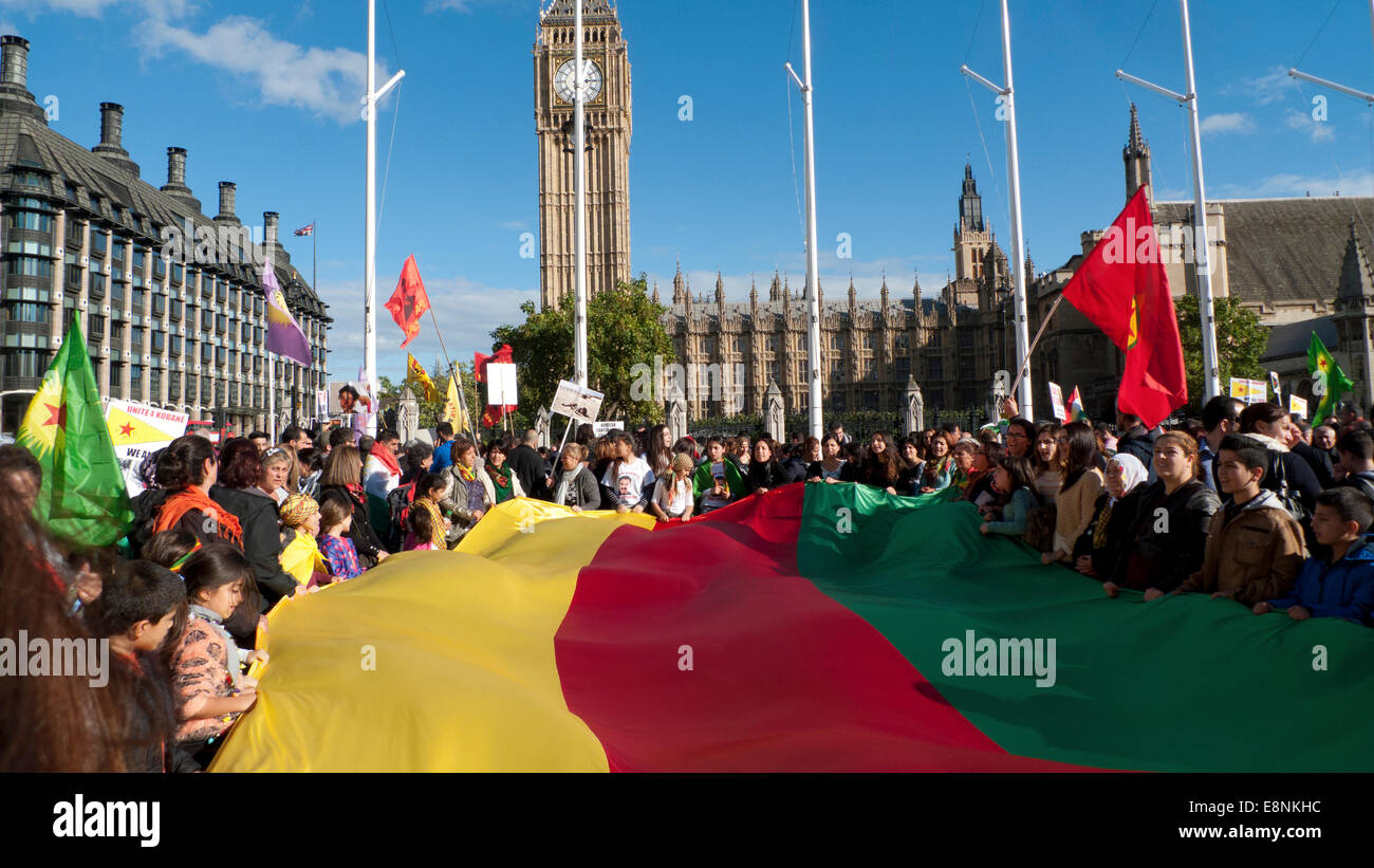 La place du parlement, Londres UK. 11 octobre 2014. Les gens se réunissent au Parlement kurde en carrés pour manifester contre l'agression écrasante d'ISIS, manque de soutien dans la protection des Kurdes dans la ville de Kobane en Syrie et de gouvernement de l'AKP turc anti ondes plaques . Les femmes et les enfants occupent une bannière aux couleurs de l'indicateur pour afficher leur solidarité dans la lutte contre l'Etat islamique. Kathy deWitt/Alamy Live News Banque D'Images