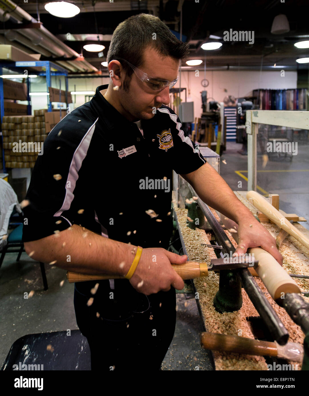 Louisville, Kentucky, USA. 12 octobre, 2014. Les copeaux de bois voler comme ANTHONY SCIOTTI démontre comment une batte de base utilisé pour être fait à la main sur un tour au Musée Louisville Slugger et de l'usine. A Louisville Slugger baseball depuis les années 1880 et est le plus important fabricant de chauves-souris dans le pays. Crédit : Brian Cahn/ZUMA/Alamy Fil Live News Banque D'Images