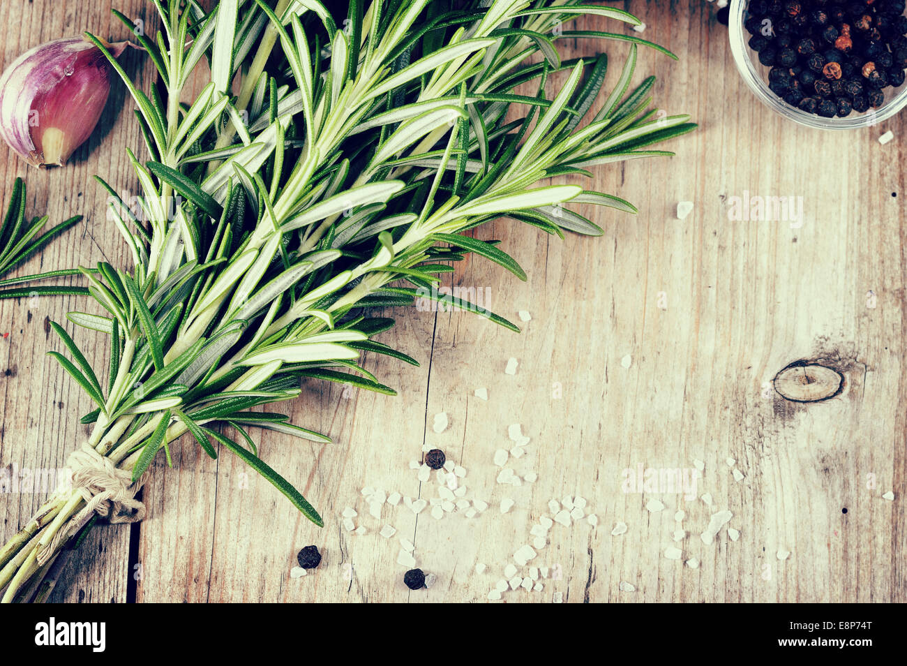Bouquet Frais de romarin, l'ail, le poivre et le sel sur la table en bois. Evergreen herb, beaucoup d'aromatiques - culinaires viandes grillées. Copysp Banque D'Images