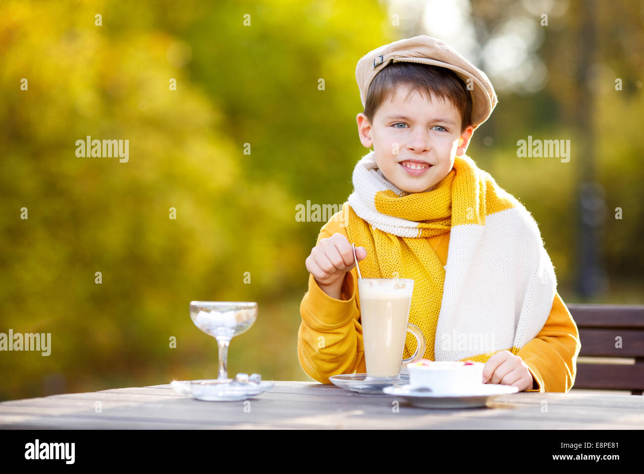 Little Boy drinking hot chocolate in cafe Banque D'Images