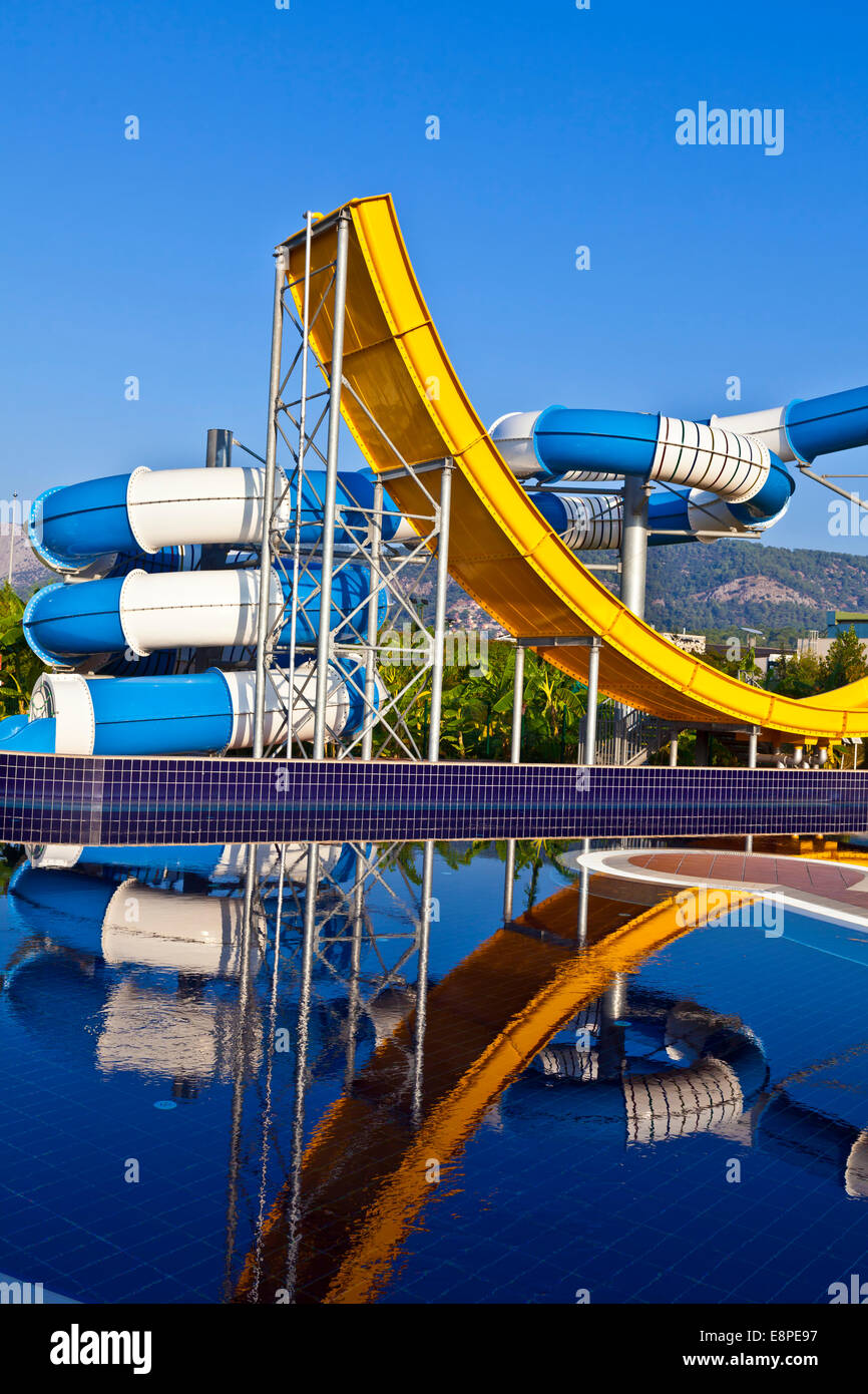 Bleu, blanc et jaune toboggan dans une piscine. Banque D'Images