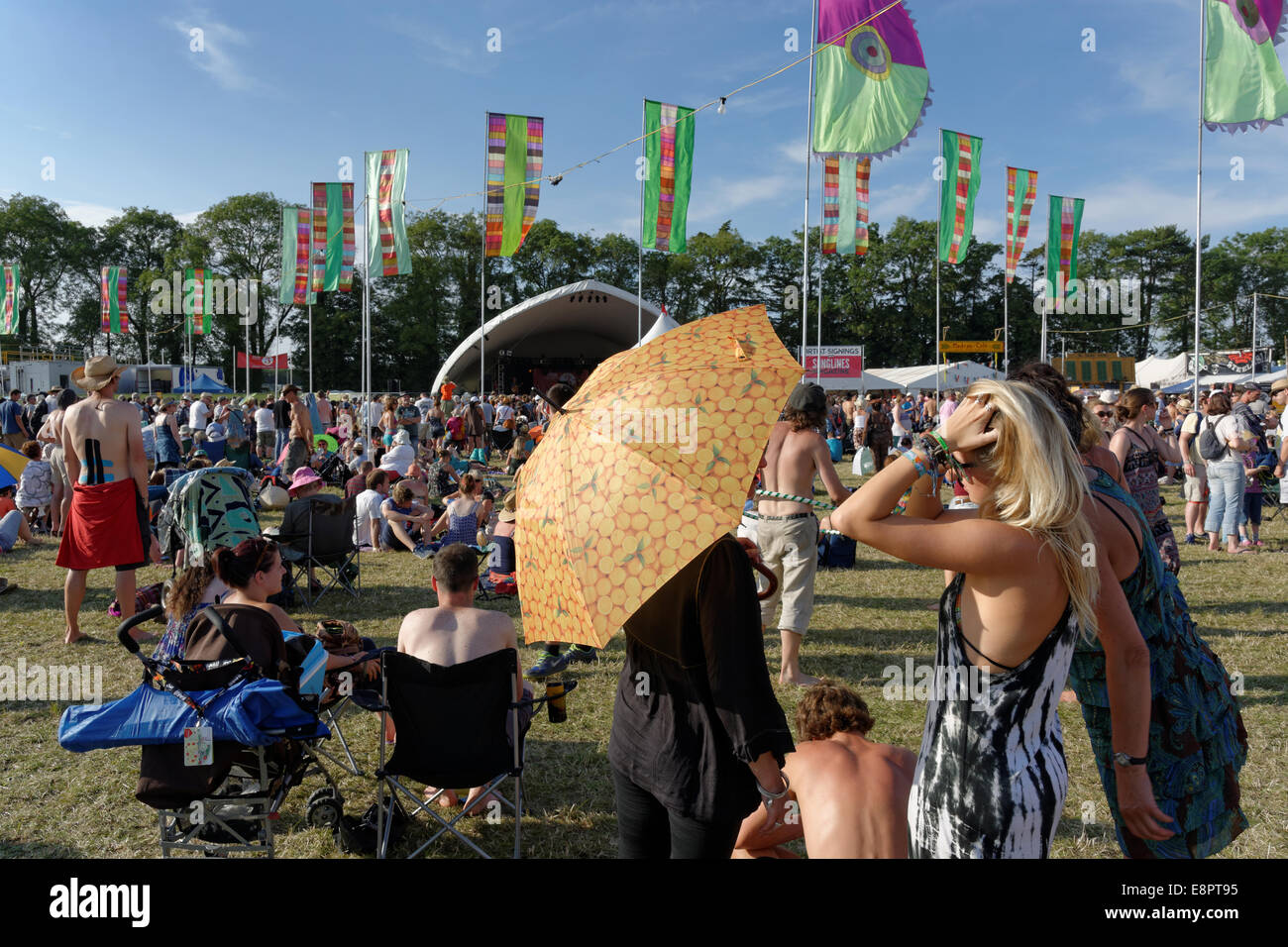 Audience, vague de chaleur, bains de soleil, parapluies, radio 3 Stage, WOMAD 2014, Charlton Park, Wiltshire, Angleterre, Royaume-Uni, GB. Banque D'Images