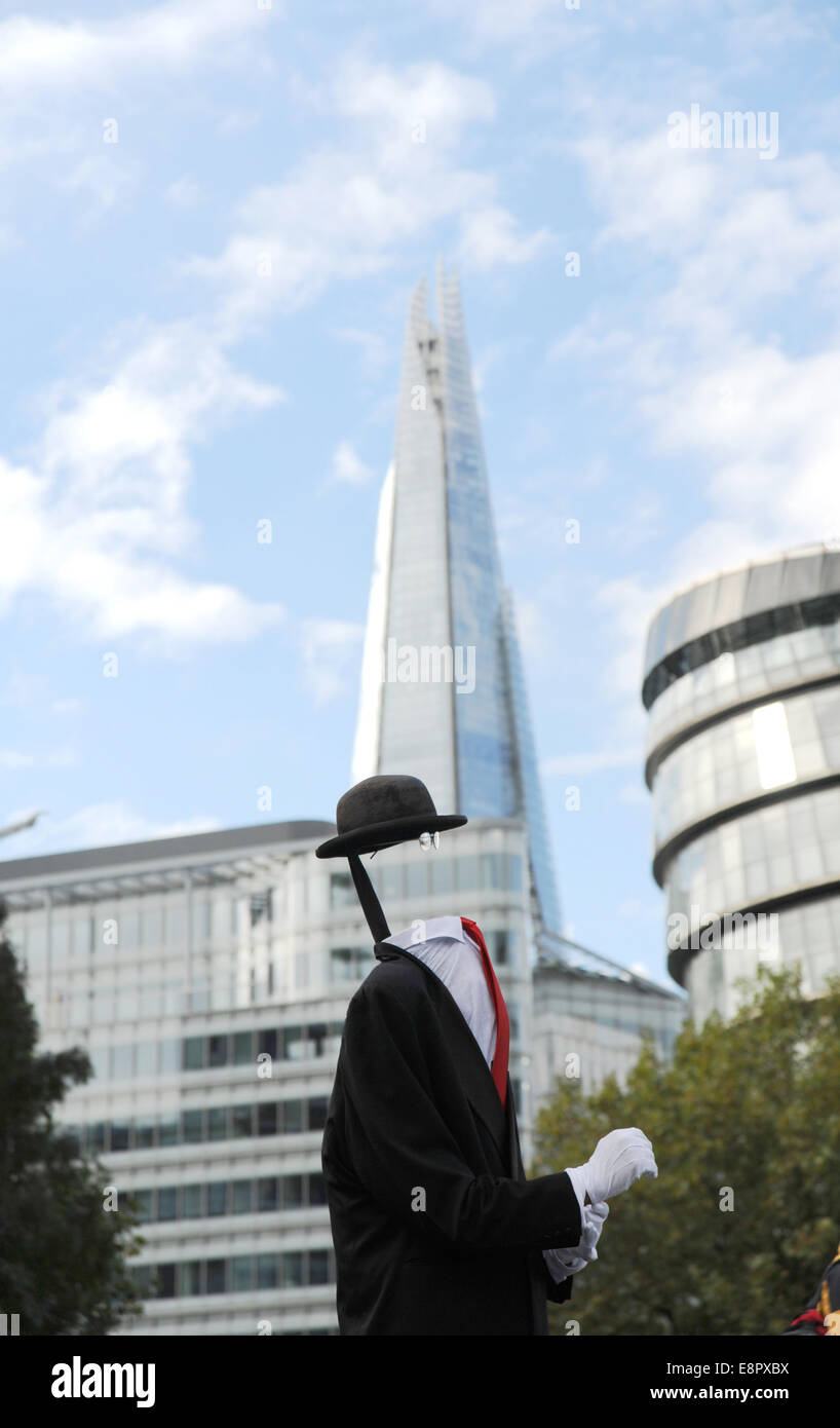 London UK - Musicien ambulant de la copie d'une peinture de Magritte René Fils de l'homme avec le fragment derrière Banque D'Images
