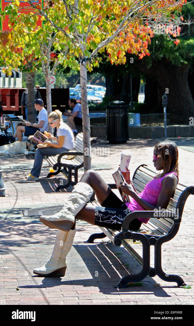 Femme avec de hautes bottes assis sur un banc à Mill Valley Park Banque D'Images