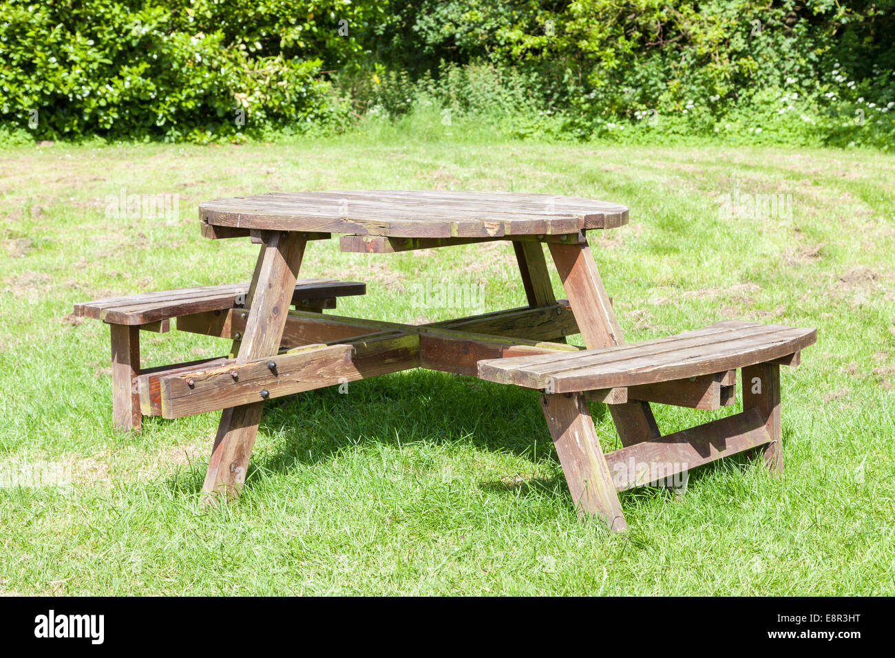 Table ronde en bois table de pique-nique et d'un coin de l'herbe dans un parc de pays, Dorset, England, UK Banque D'Images