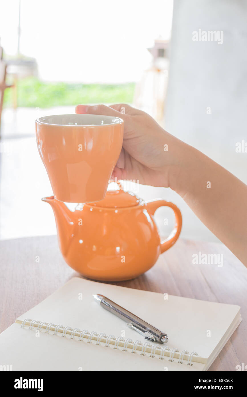 Prise de main sur une tasse de thé chaud Banque de photographies