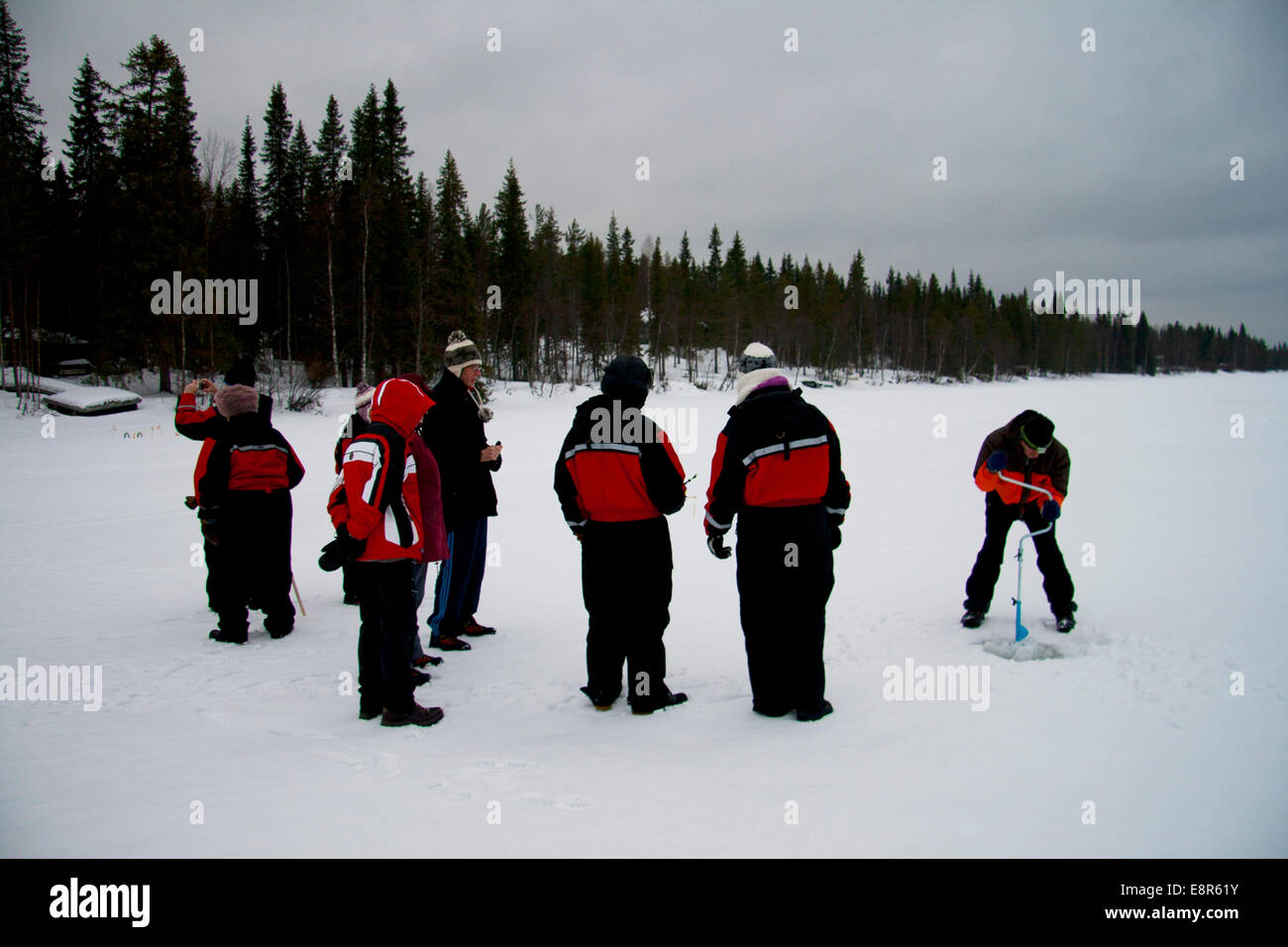 Guide Lapp démontrant la glace traditionnelle technique de pêche sur le lac Pyhajarvi, KAIROS, la Finlande. Banque D'Images
