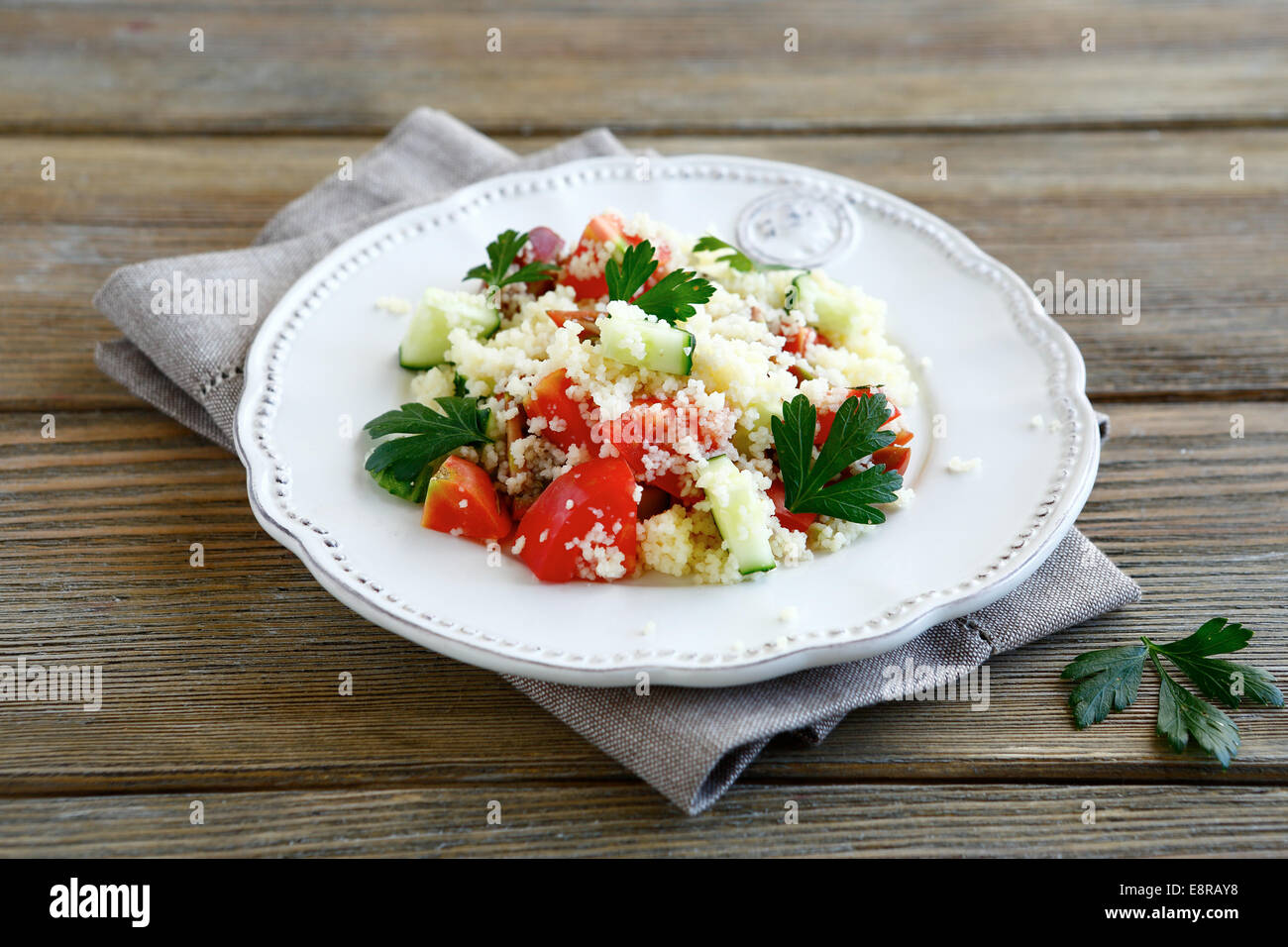 Délicieux avec la salade de couscous et légumes arabe sur une assiette, de l'alimentation sur un panneaux de bois Banque D'Images