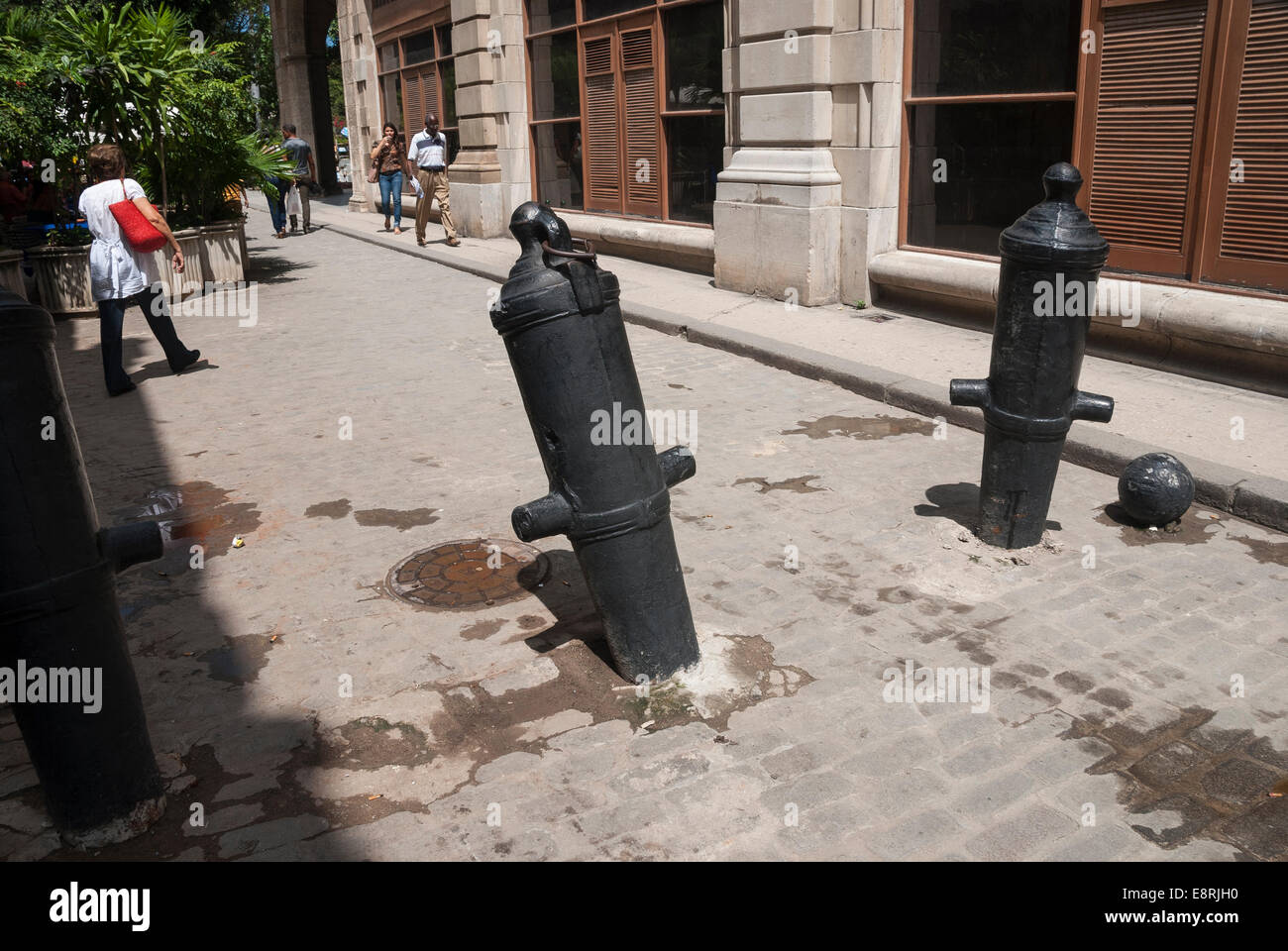 Vieux canons et boulets fixés à la route et utilisés comme barrières de contrôle de la circulation dans le vieux quartier de La Havane Cuba Banque D'Images