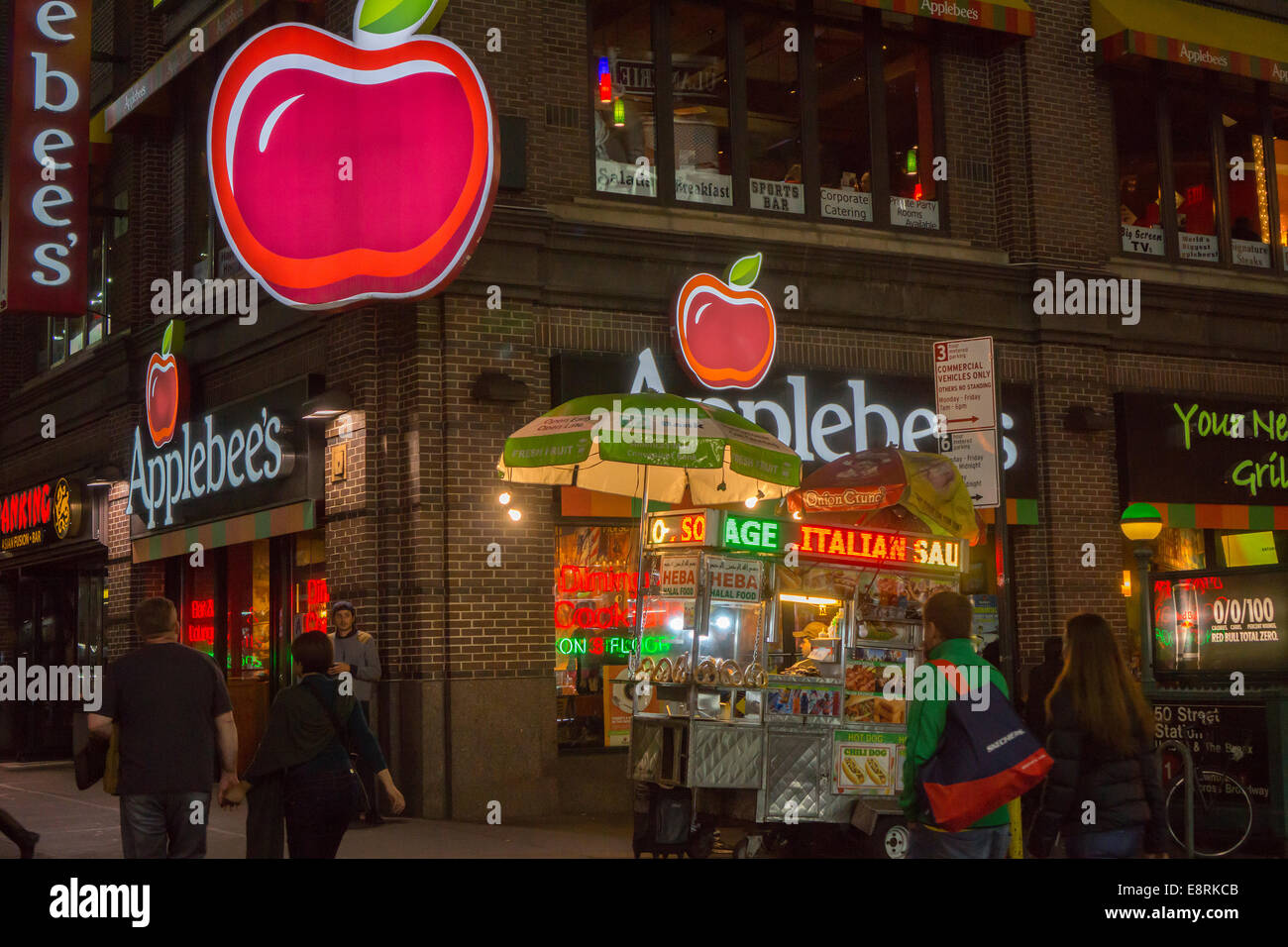 Un vendeur de hot-dog partage un coin avec un Times Square de la direction générale de la chaîne de restaurants Applebee's Banque D'Images