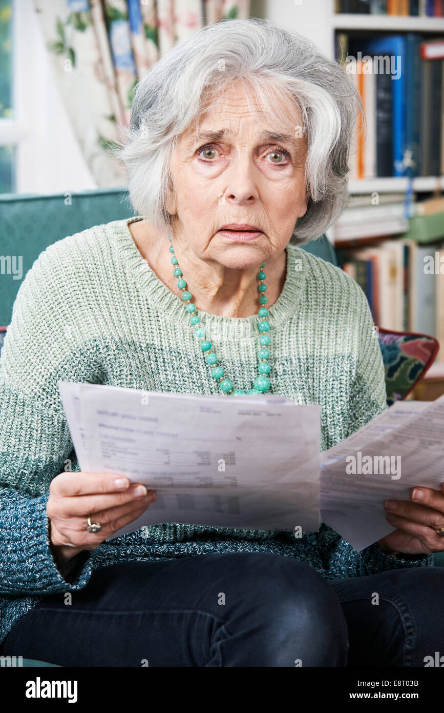 Senior Woman en passant par les projets de loi et à la peur Banque D'Images