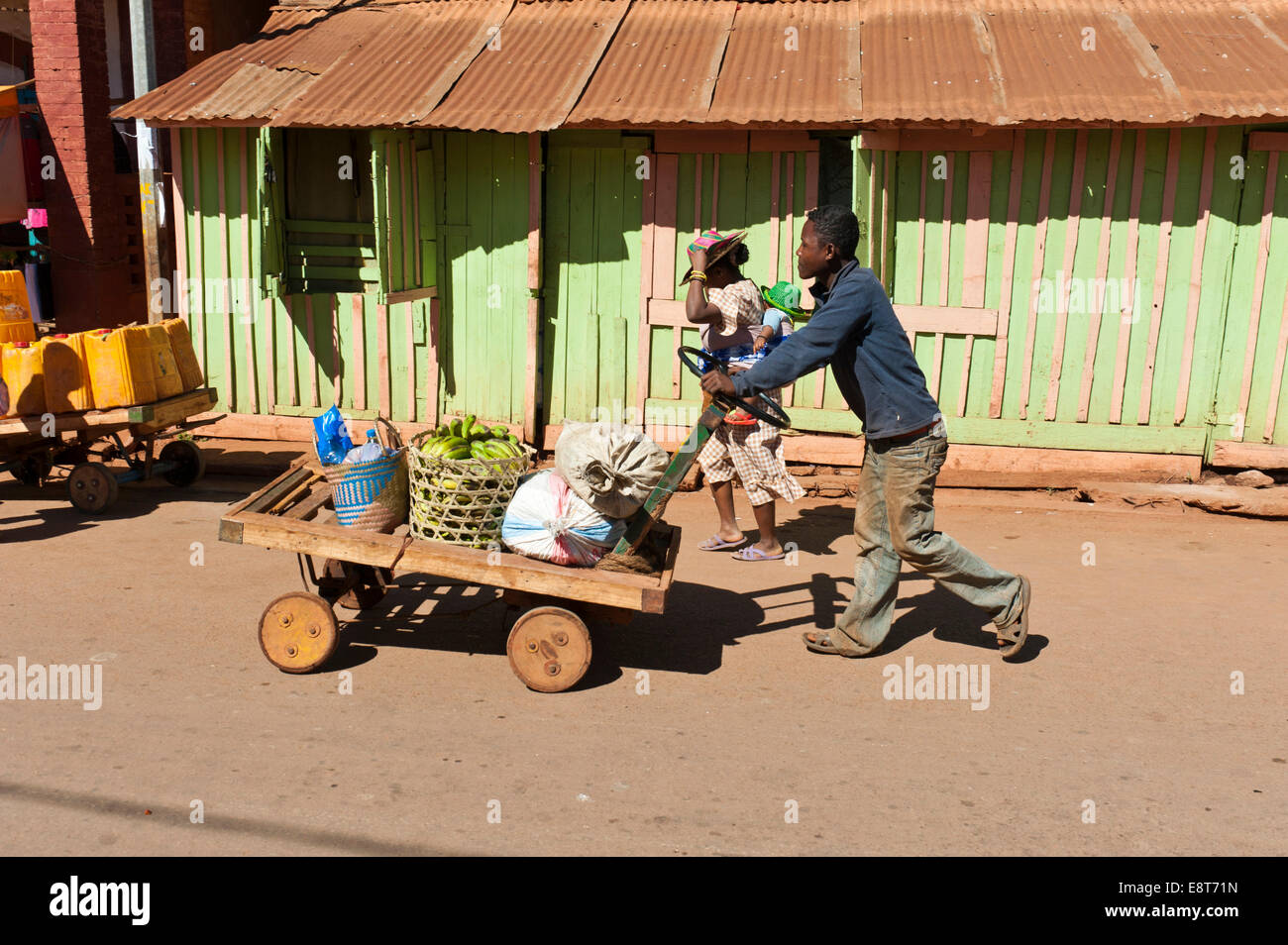 Homme pousse des marchandises sur un panier fait maison, Ambalavao, Madagascar Banque D'Images