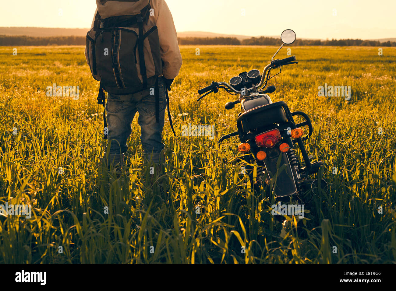 Mari man standing in field with motorcycle Banque D'Images