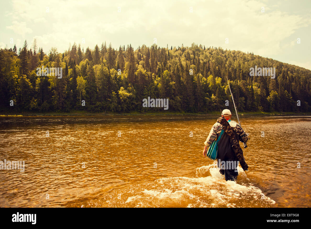 Mari pêcheur transportant la canne à pêche dans le lac Banque D'Images