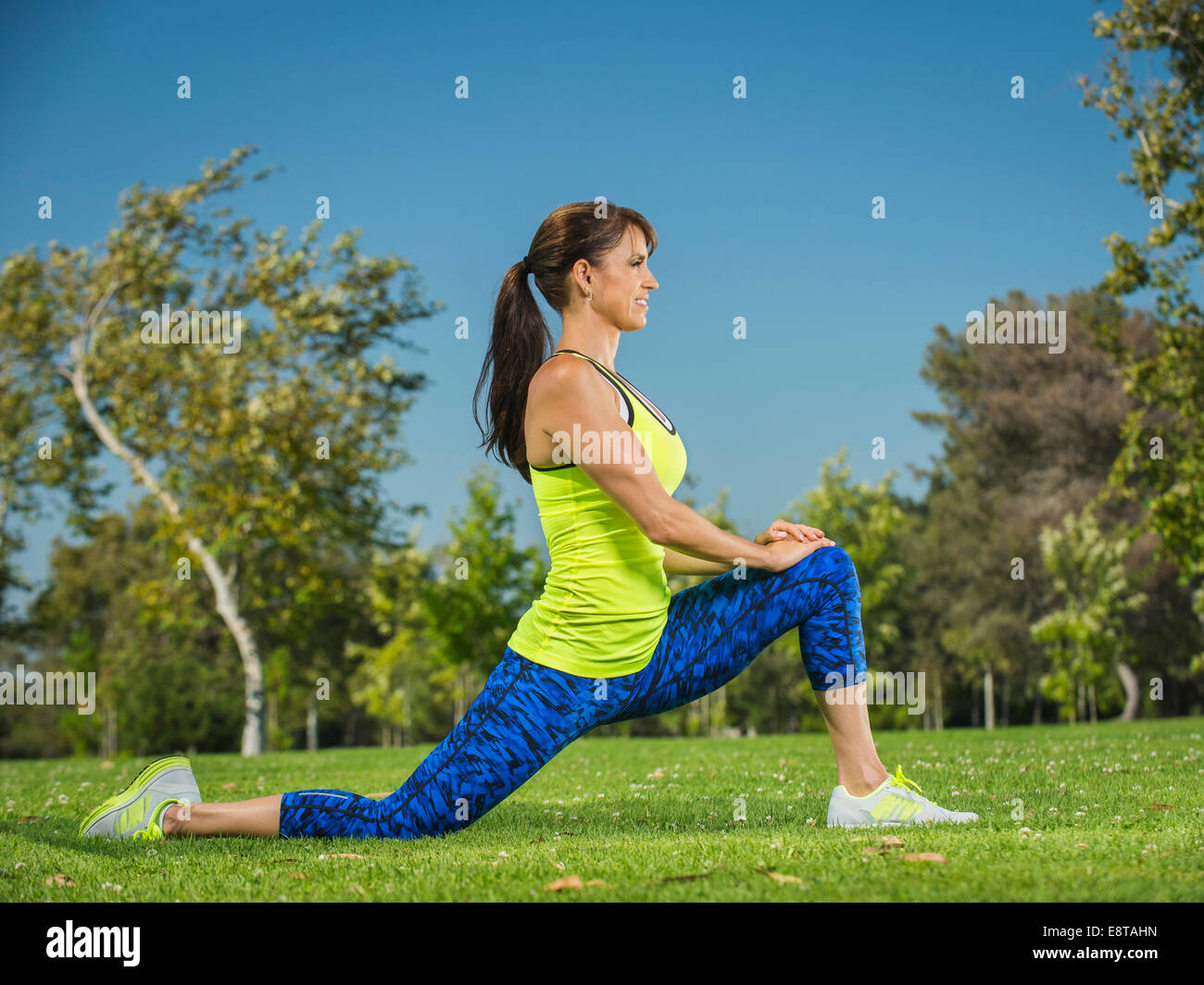 Mixed Race woman stretching in park Banque D'Images