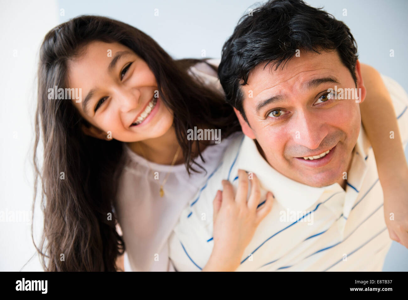 Hispanic father carrying daughter piggyback Banque D'Images