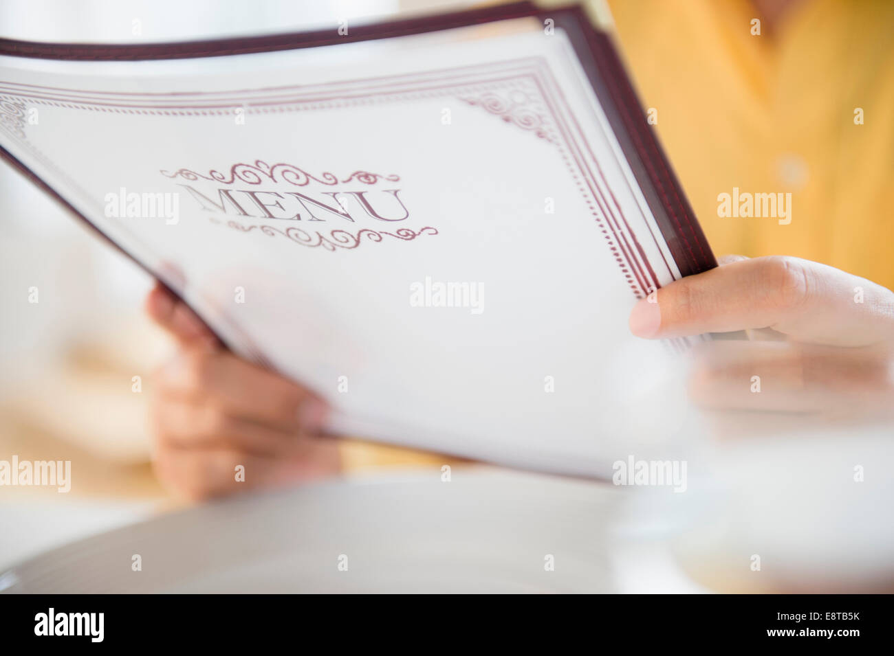 Close up of mixed race man reading menu in restaurant Banque D'Images