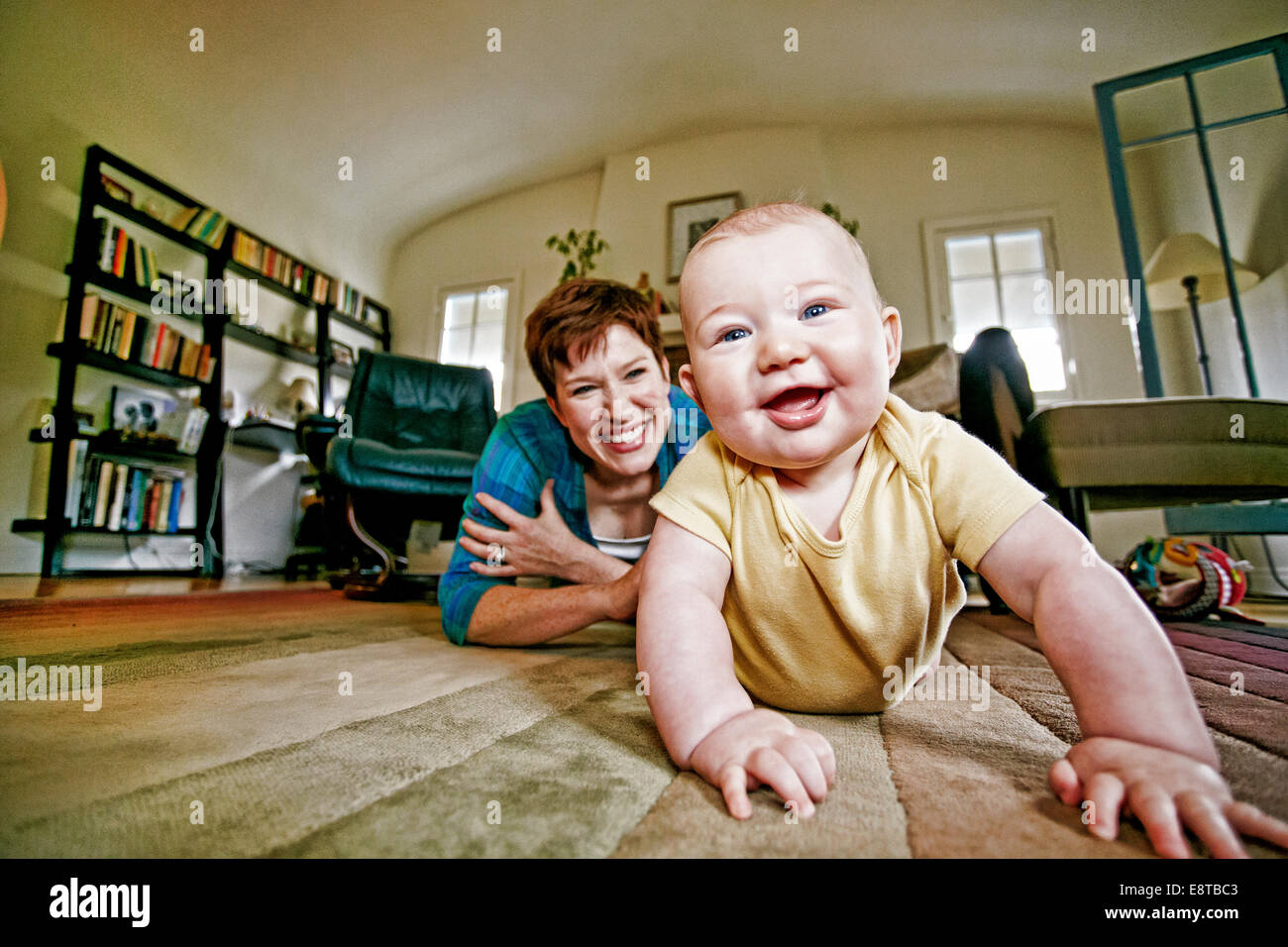 La mère et l'enfant de race blanche jouant sur plancher du salon Banque D'Images