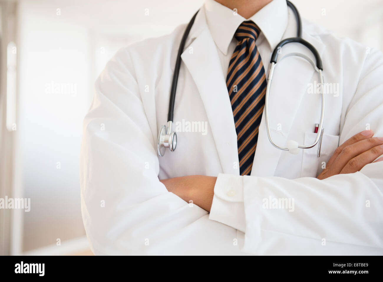 Close up of mixed race doctor with arms crossed Banque D'Images