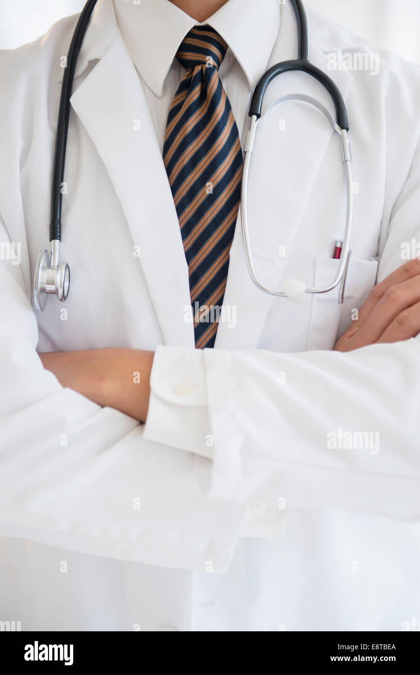 Close up of mixed race doctor with arms crossed Banque D'Images