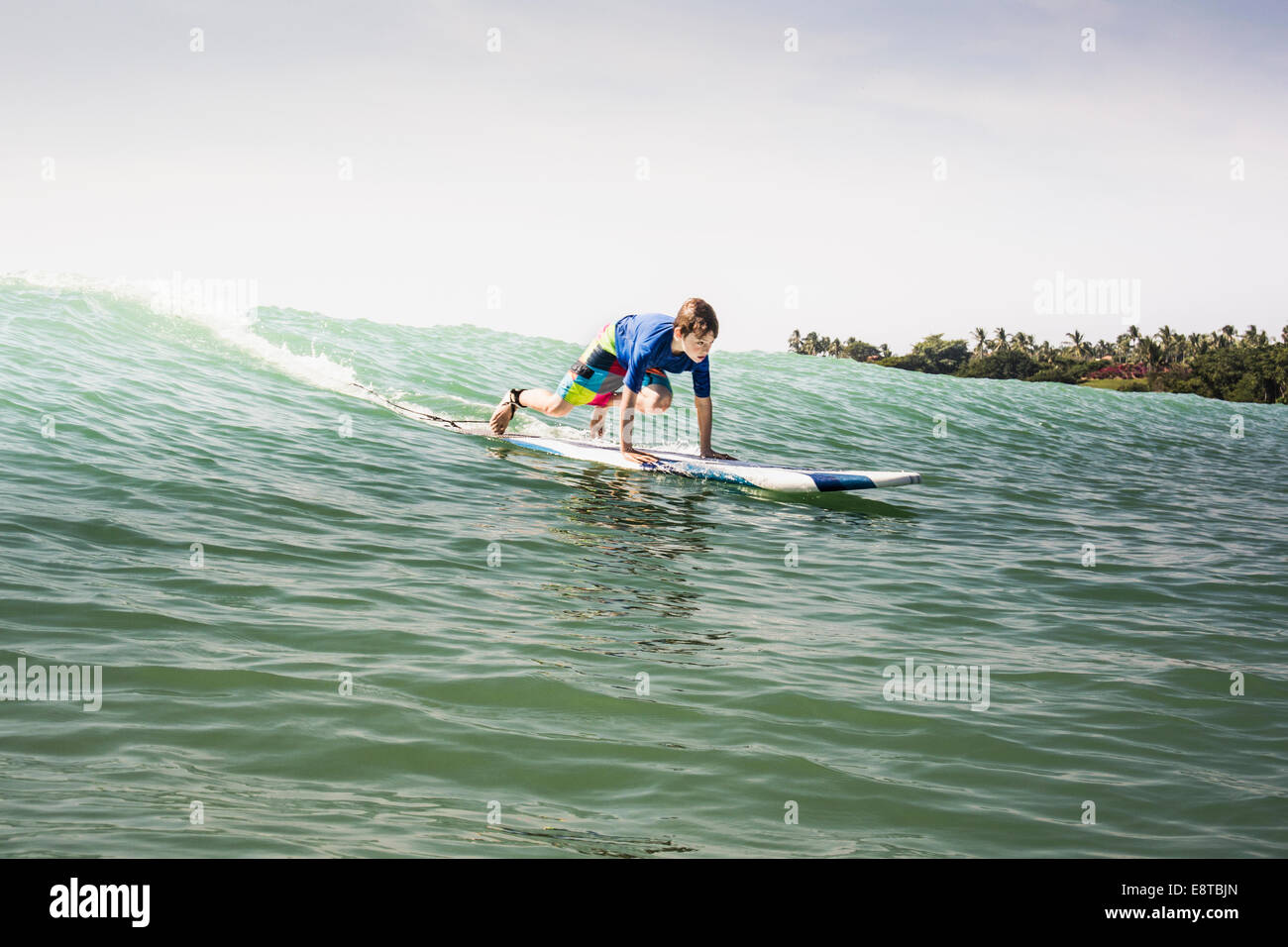 Young boy surfing in ocean Banque D'Images