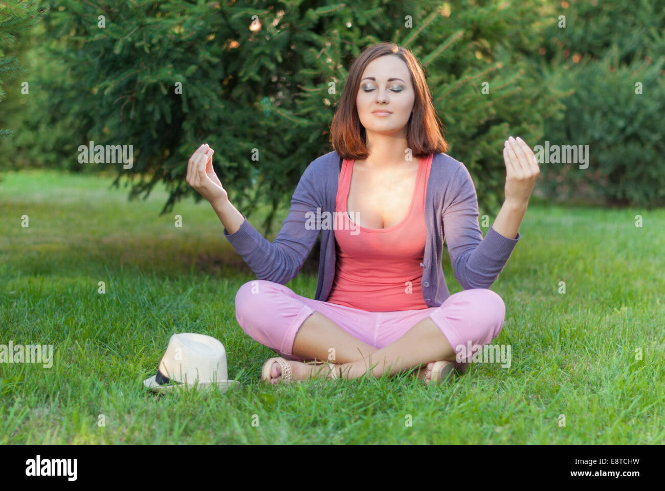 Young woman doing yoga des exercices dans l'été green city park. Banque D'Images