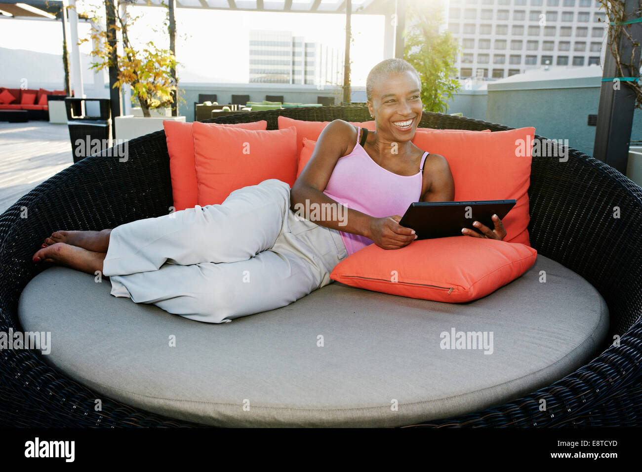 Black woman using digital tablet on urban rooftop Banque D'Images