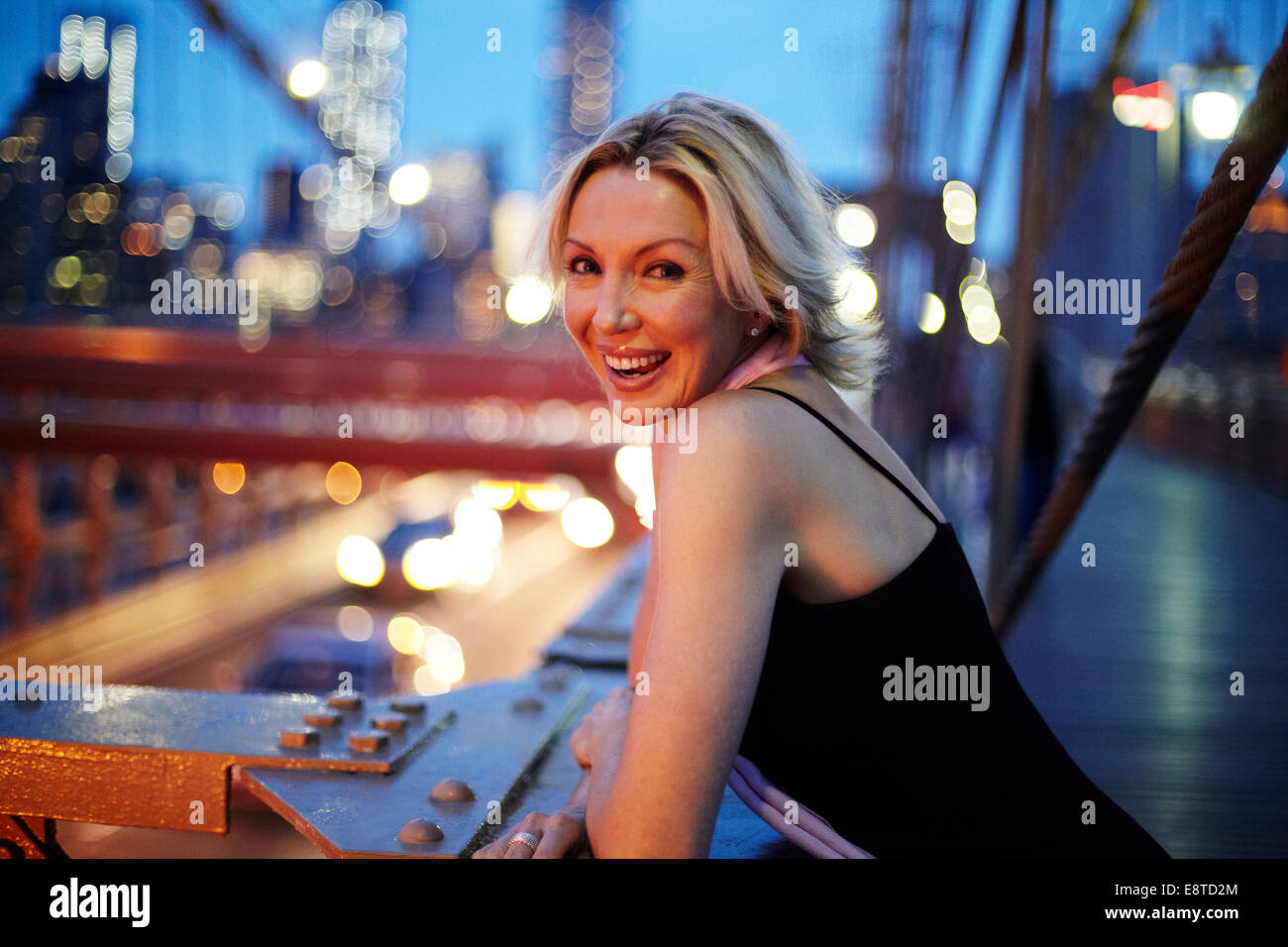 Caucasian woman leaning on railing on Brooklyn Bridge, New York City, New York, United States Banque D'Images