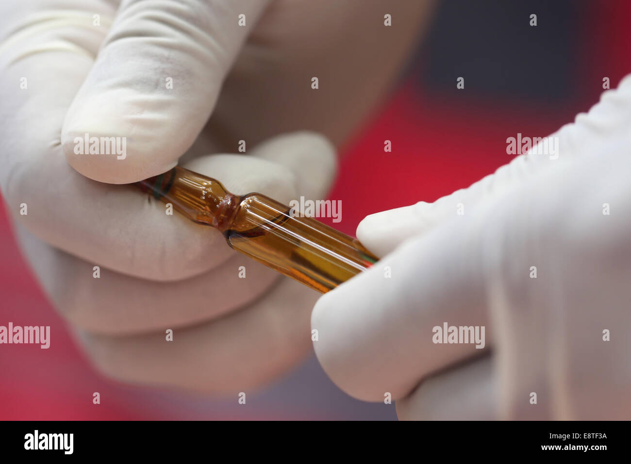 Close up de l'ampoule tenue par les mains avec des gants. Banque D'Images