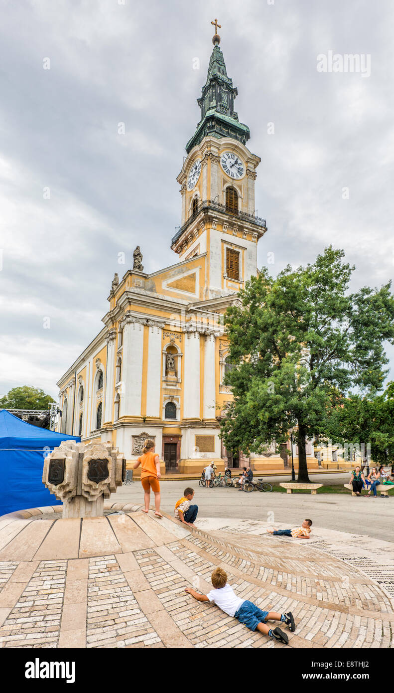 Les enfants jouer en face d'une grande église, le style baroque tardif, 1806, à Kecskemet, Hongrie Banque D'Images
