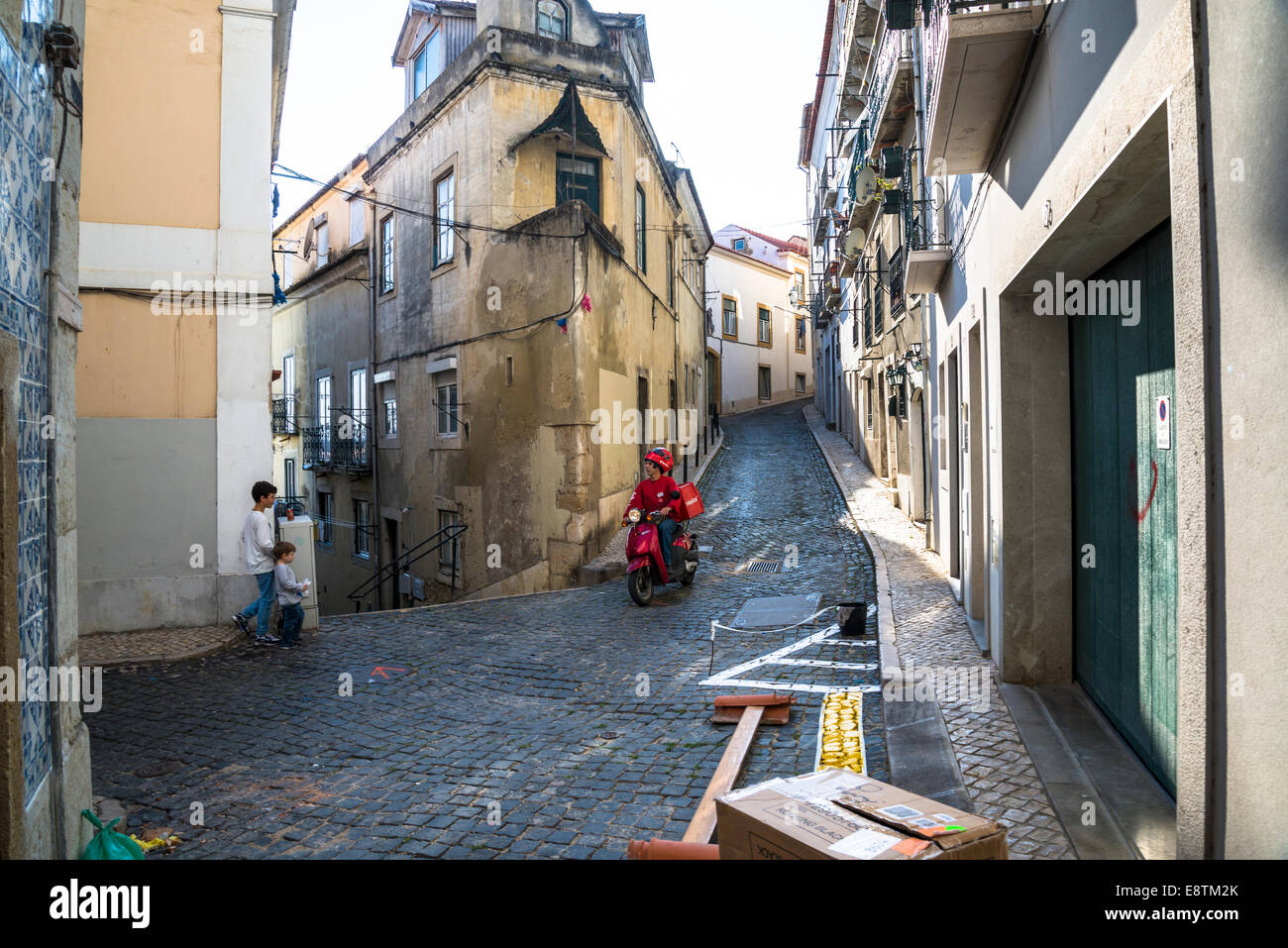 Scène de rue dans l'Alfama avec l'homme en scooter et deux enfants, Lisbonne, Portugal Banque D'Images