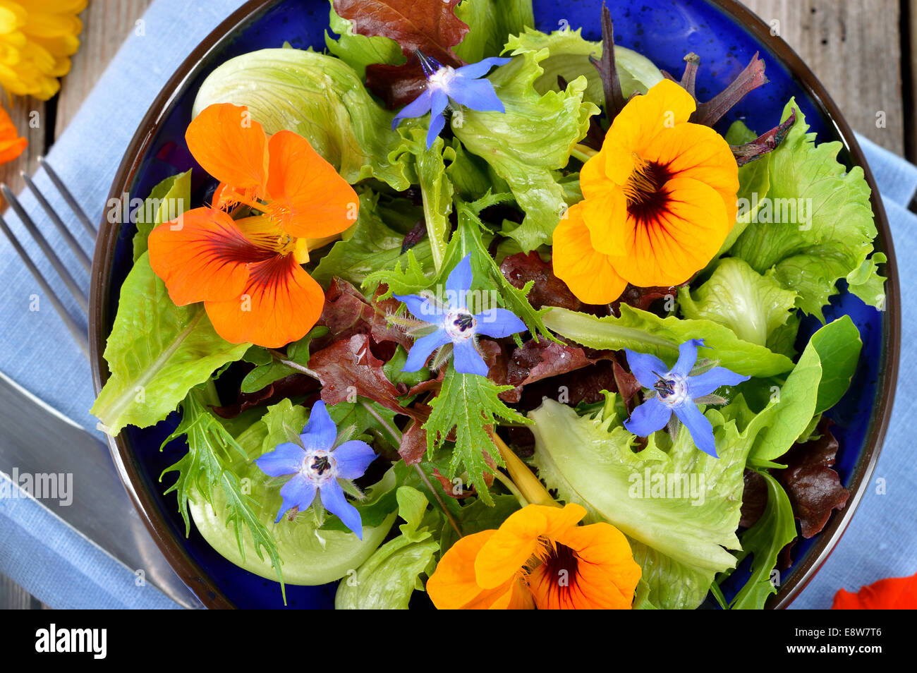 Salade d'été frais avec des fleurs comestibles, fleurs de bourrache capucine dans un bol. Vue d'en haut. Banque D'Images