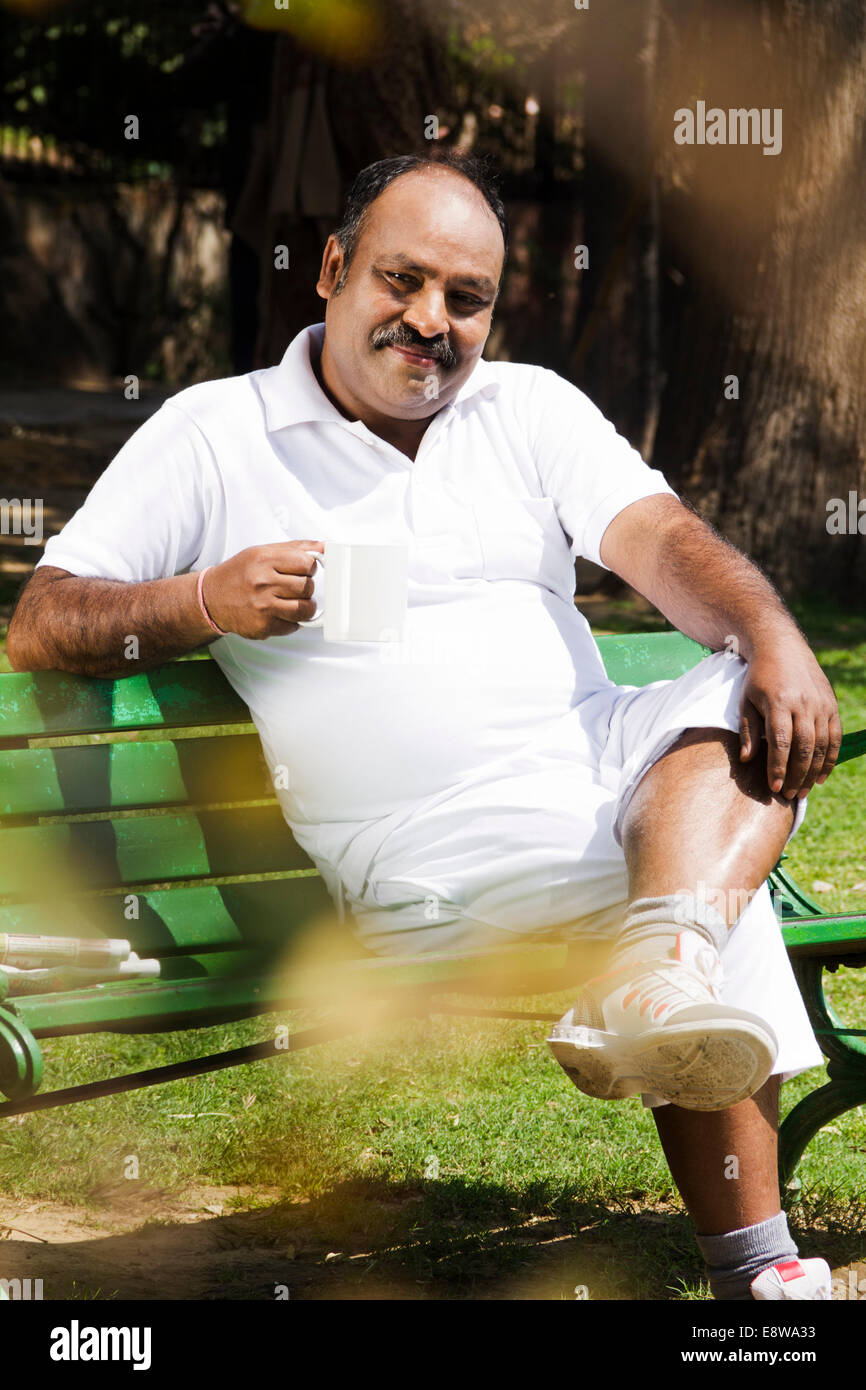 1 Indian Man Sitting in Park et boire le thé Banque D'Images