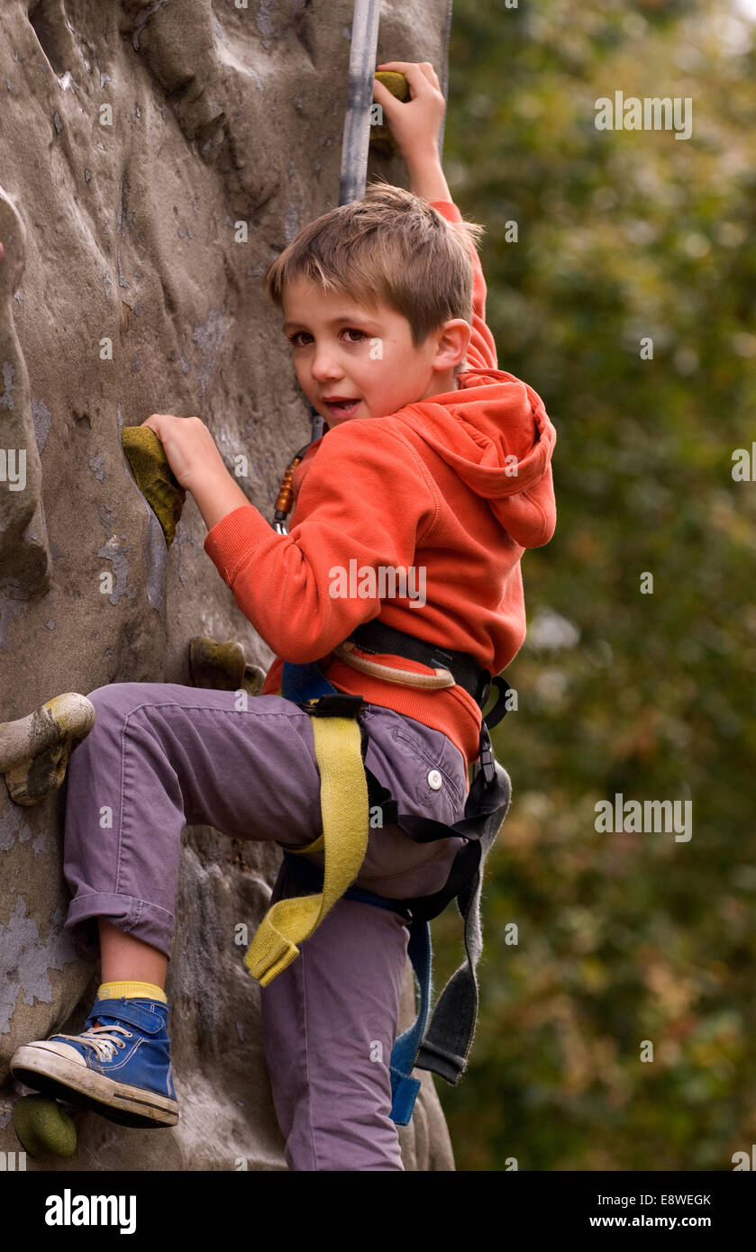 Jeune garçon d'essayer le mur d'escalade dans une ferme journée portes ouvertes, blackmoor, Hampshire, Royaume-Uni. Banque D'Images