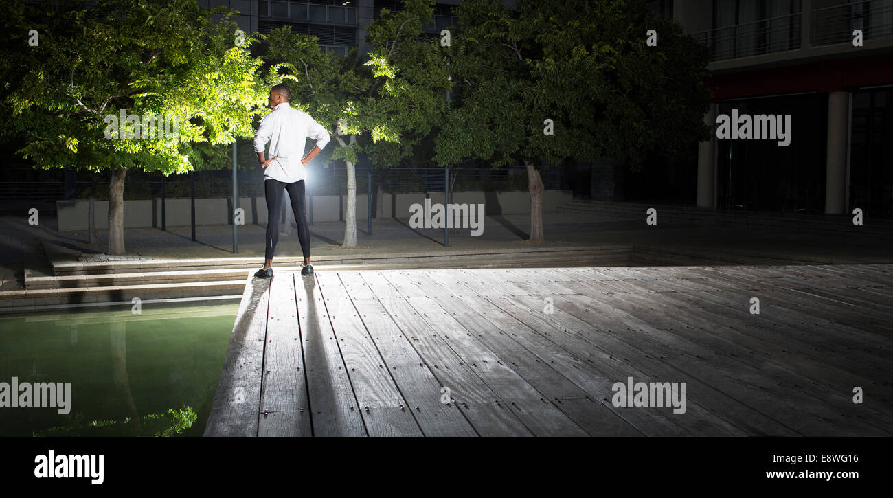 Homme debout en parc de nuit Banque D'Images