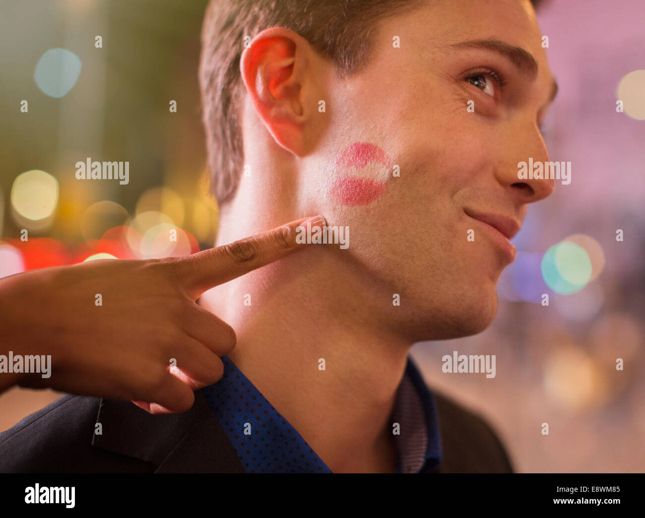 Homme posant avec impression de rouge à lèvres sur la joue en ville Banque D'Images