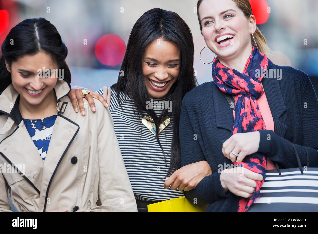 Les femmes rire ensemble on city street Banque D'Images