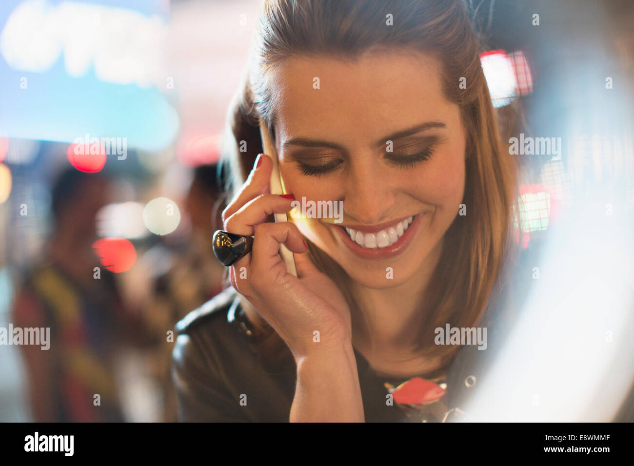 Woman taking on cell phone on city street at night Banque D'Images