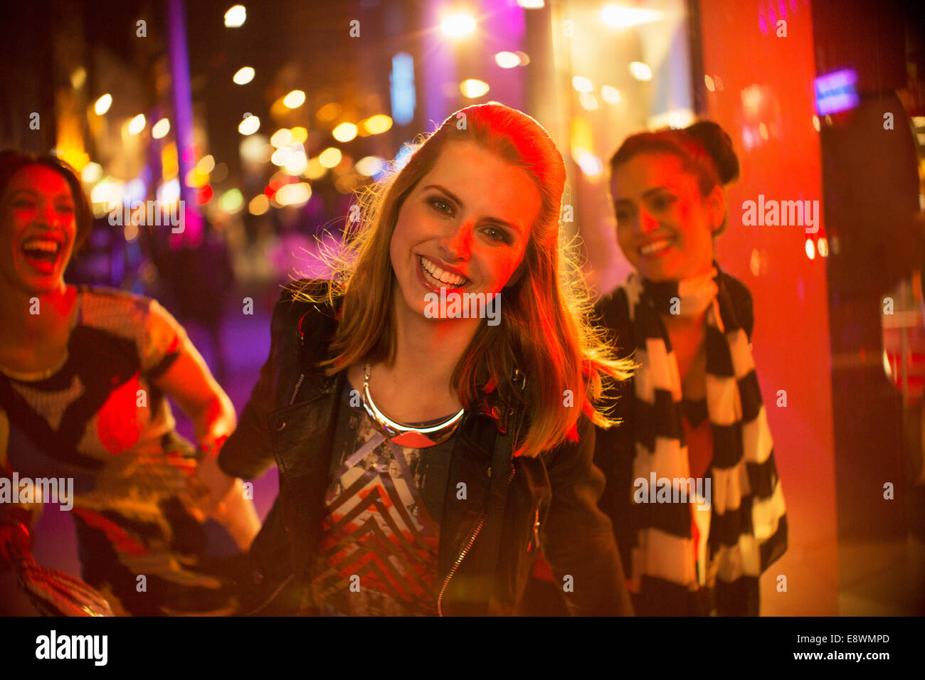 Amis jouant sur city street at night Banque D'Images