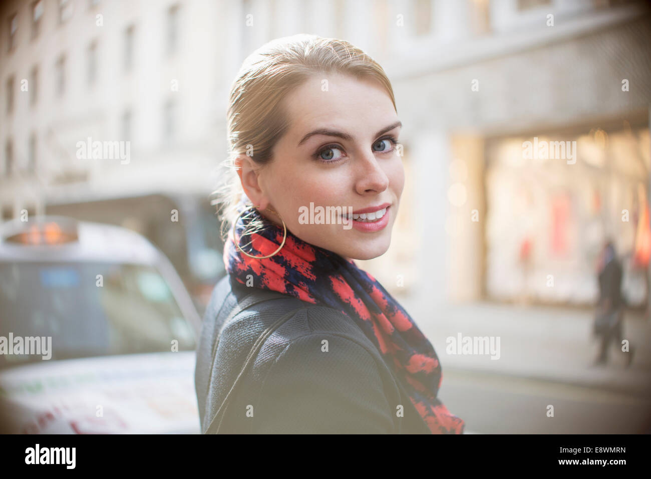 Woman smiling on city street Banque D'Images