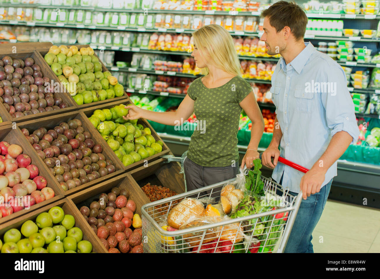 Couple shopping ensemble à produire section of grocery store Banque D'Images