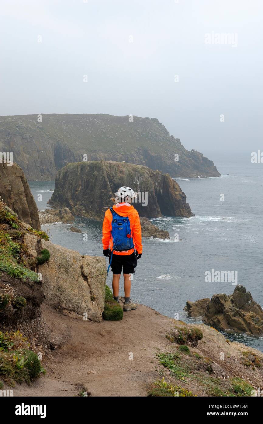 Un randonneur à la seule femme sur le bord de la falaise à Lands End Cornwall UK Banque D'Images